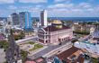 Beautiful drone aerial view of iconic theater, city center houses, buildings and streets in sunny summer day in Amazon Rainforest. Rio Negro in the background.