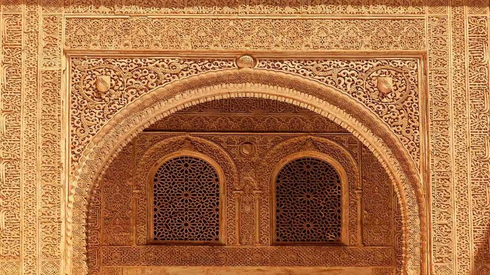 Close up of a very intricate carved archway within two windows in