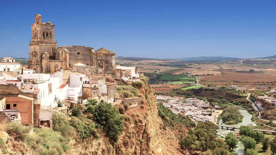 Stunning view out to countryside, with a white town built onto the cliff on the left side