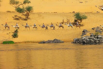tpurists riding camels on the banks of the nile