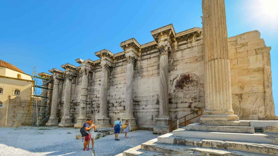Exterior of Hadrians Library on the Acropolis, with tourists walking