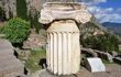 Ancient column in Ancient Greek archaeological site of Delphi shown at warm evening light, Central Greece