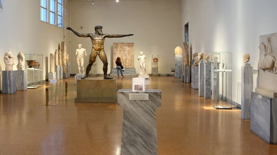Exhibits inside the museum, including a bronze statue of a god