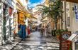 Tourists walk the streets lined with souvenir and gift shops and outdoor sidewalk cafes in Plaka