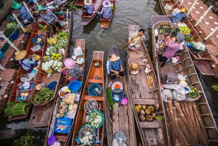 Overhead view of long tail boats with vendors selling food products