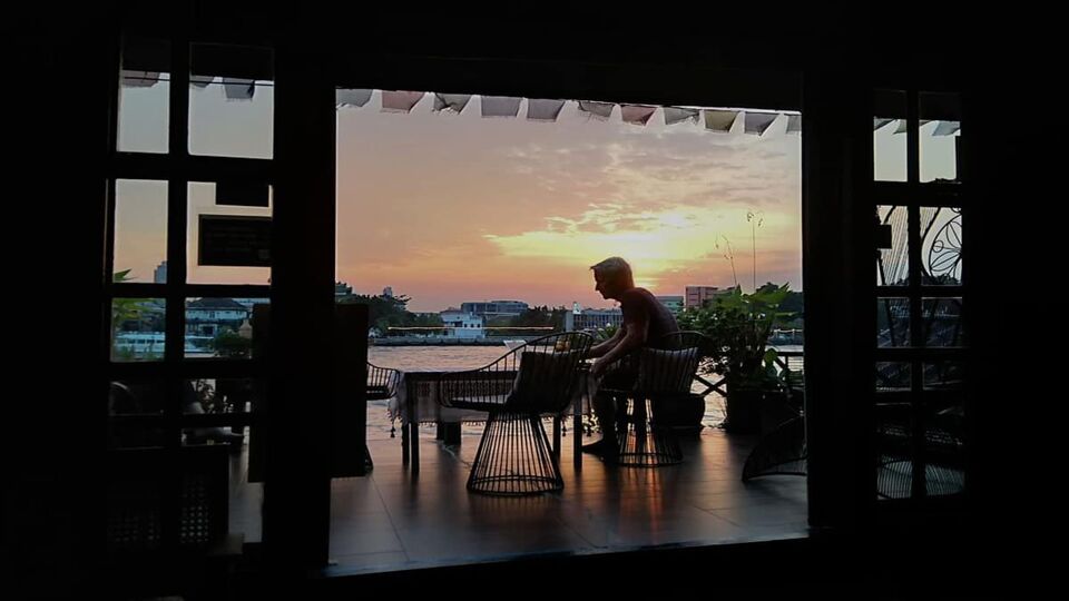 Sunset view over the river from a balcony with someone relaxing