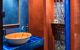 Bathroom with blue and orange walls, colourful tiles, and an orange sink