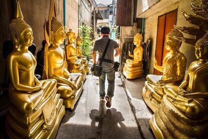 Man walking through golden Buddha road