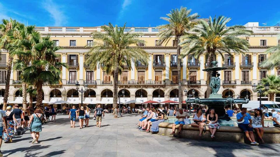 View of a lovely square with palm trees and tourists