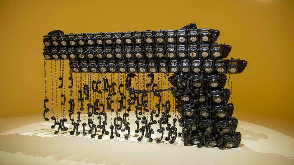 Installation made from black telephones that looks like a gun