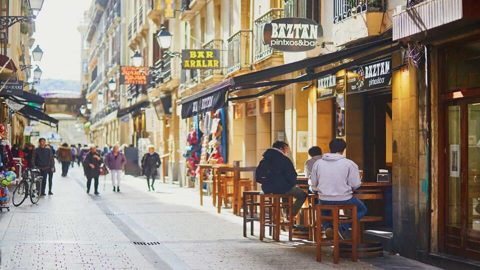 street with shoppers and people sitting at bar tables