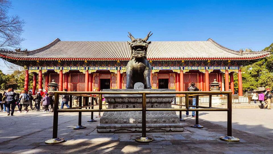 view of a qilin statue infront of temple entrance