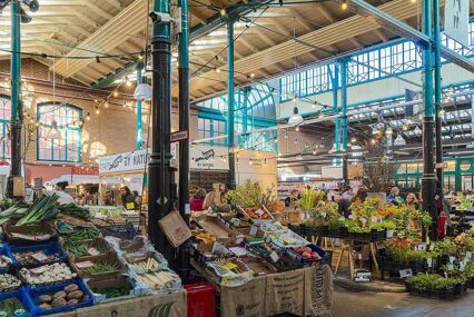 Interior of the MarktHalle 9 with stalls and fresh produce