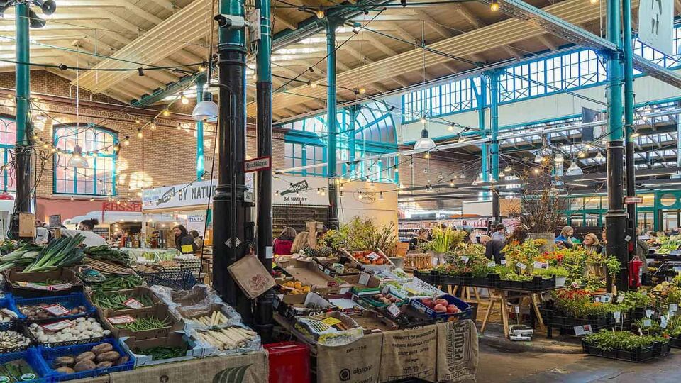 Interior of the MarktHalle 9 with stalls and fresh produce