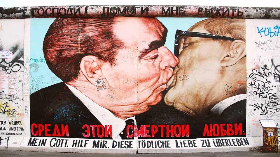 graffiti painting of two men kissing on the berlin wall
