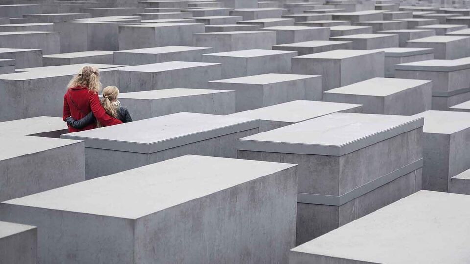 woman and child in the jewish memorial between slabs of stone