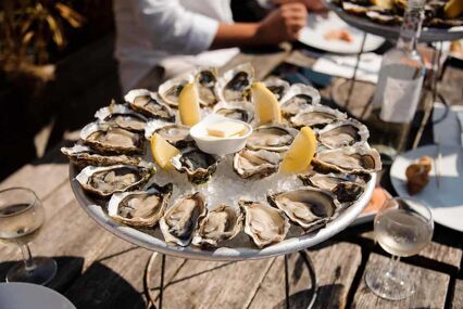 Tasty oysters on the half shell served flat lay on wooden background directly above view