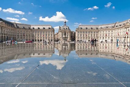 Exterior of Palace de la Bourse, doubled in the reflection of a puddle