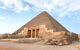 The entrance of the mastaba of Seshemnufer IV late 5th Dynasty and the Great Pyramid in background. The Pyramid Fields from Giza to Dahshur is on UNESCO World Heritage List