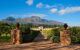 Entry gate to the estate with a long driveway to the estate building, through a vineyard