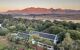 Aerial view down onto the estate with vineyards and mountains behind