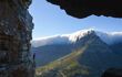 A man watching over from the ledge of a mountain