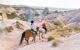 horse riders crossing a cappadocian landscape in the rose valley