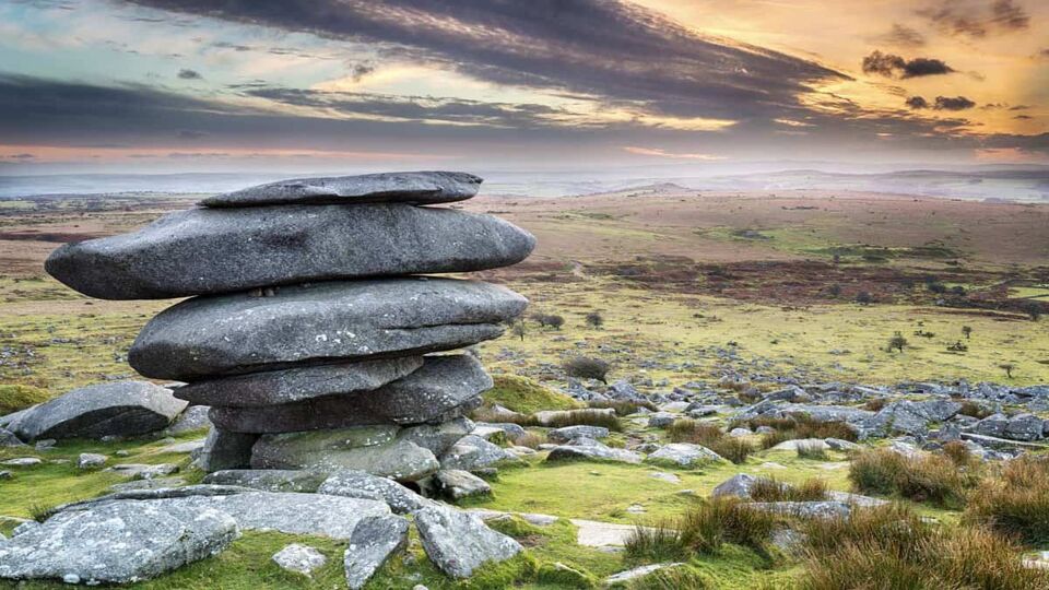 Sunset at the Cheesewring on Bodmin Moor in Cornwall, a weathered natural rock formation made up of precariously balanced granite slabs