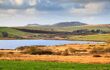 View over Colliford Lake with Brown Willy and Rough Tor hills in the distance, the highest and second highest points in Cornwall England UK