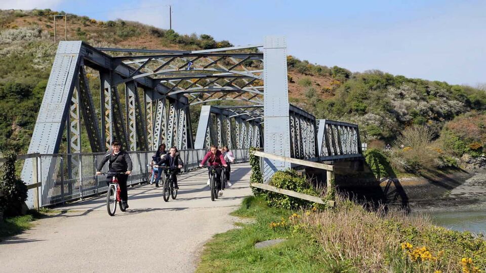 cyclists crossing railway bridge on the camel trail