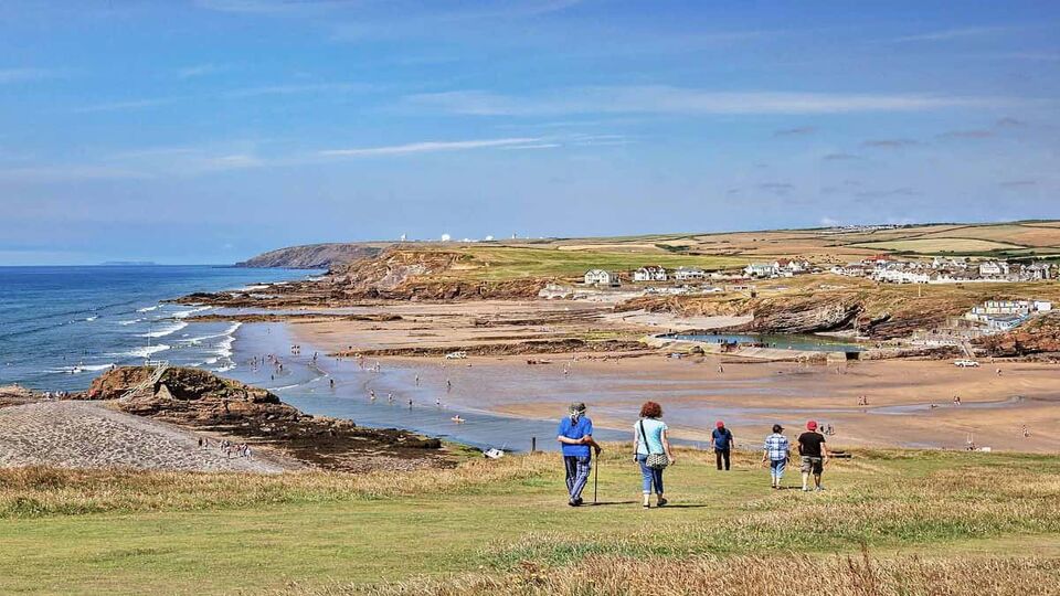 Bude, Cornwall, UK - People walking down to Summerleaze beach from Compass Point, during the summer heatwave.