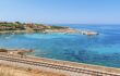 Railway track along beautiful bay in Algajola village on coast of Corsica island, France