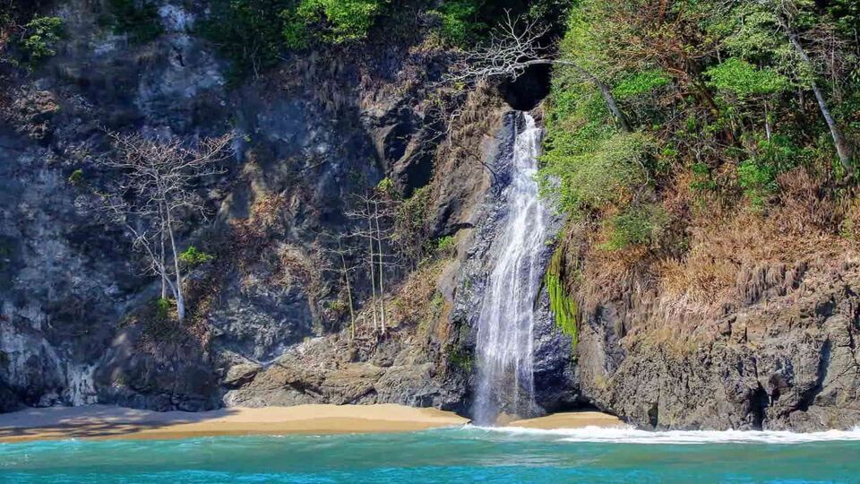 waterfall dropping down to aqua blue water