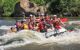 Close up of group of people on a raft navigating a rapid