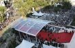 Aerial view of covered walkway and red carpet, with crowds on either side