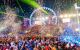 Illuminated ferris wheel with crowds in front