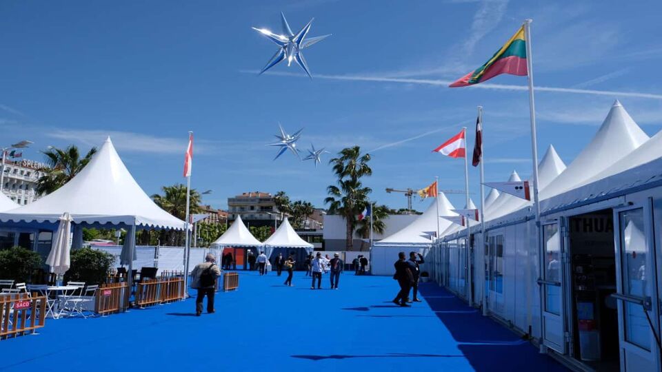 onsite area with white tents and blue carpet