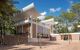 Modernist building with a courtyard in front flanked by trees