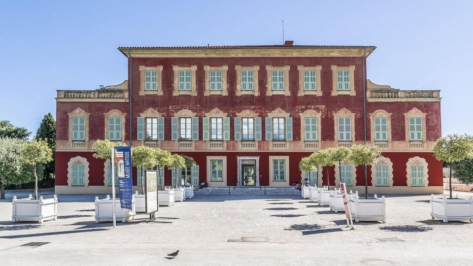 Exterior of grand, red-brick museum on a sunny day