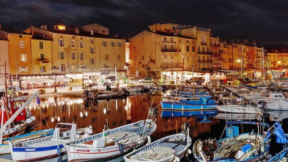 View of Saint-Tropez's port at night, filled with fishing boats