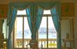 Window with sash curtains looking out to sea