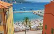 View through two colourful buildings to a beach and blue sea