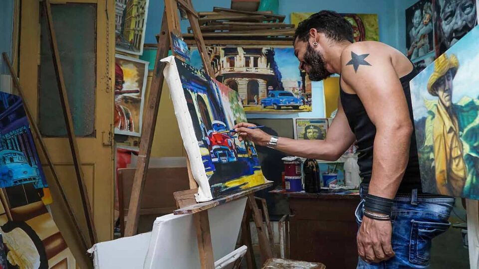 A cuban man doing paintings to sell as a souvenir