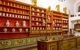 Urns and vases on colourful shelves behind cashier's desk