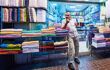Textiles shop seller waiting for buyers at colorful Bur Dubai Souk Arabian Market