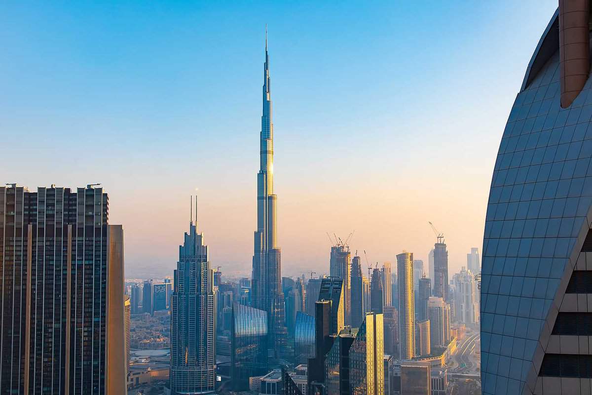 Burj Khalifa rising above Dubai downtown cityscape high angle view view at sunset. United Arab Emirates modern architecture and travel abstract