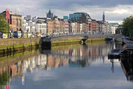 A bridge and houses reflecting in the River Liffey in the evening light