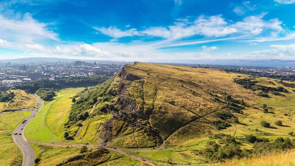 Cityscape of Edinburgh from Arthur's Seat summit in a beautiful summer day in Scotland. This photo capture the greenery and nature.
