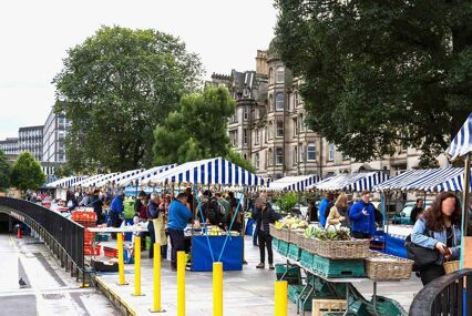 market stalls on the street with blue and white striped awnings