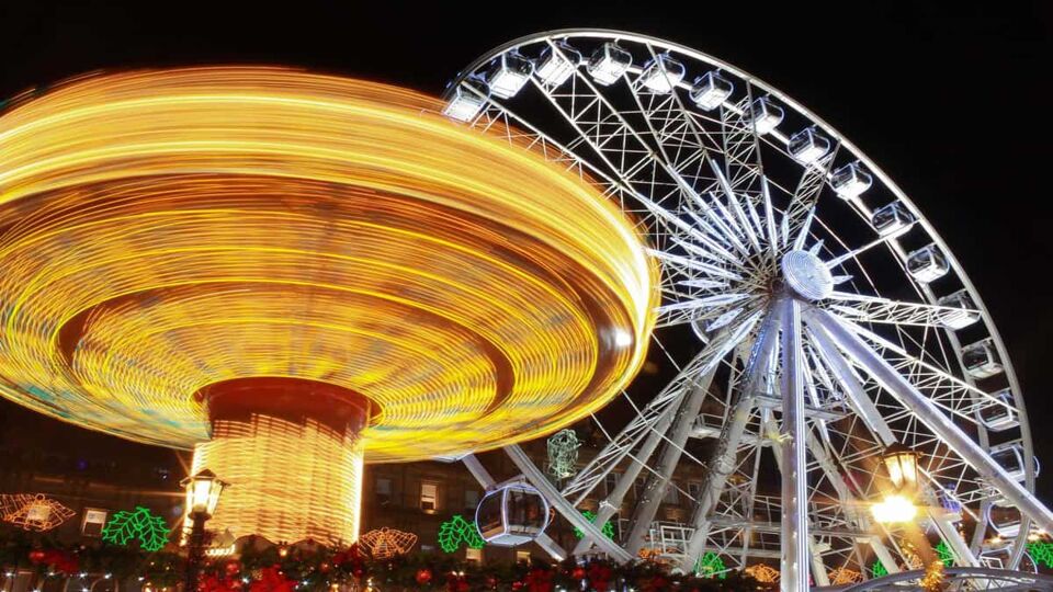 The fair in motion six and big wheel, George Square, Glasgow, Scotland, part of the Christmas and Hogmanay holiday attractions, at night